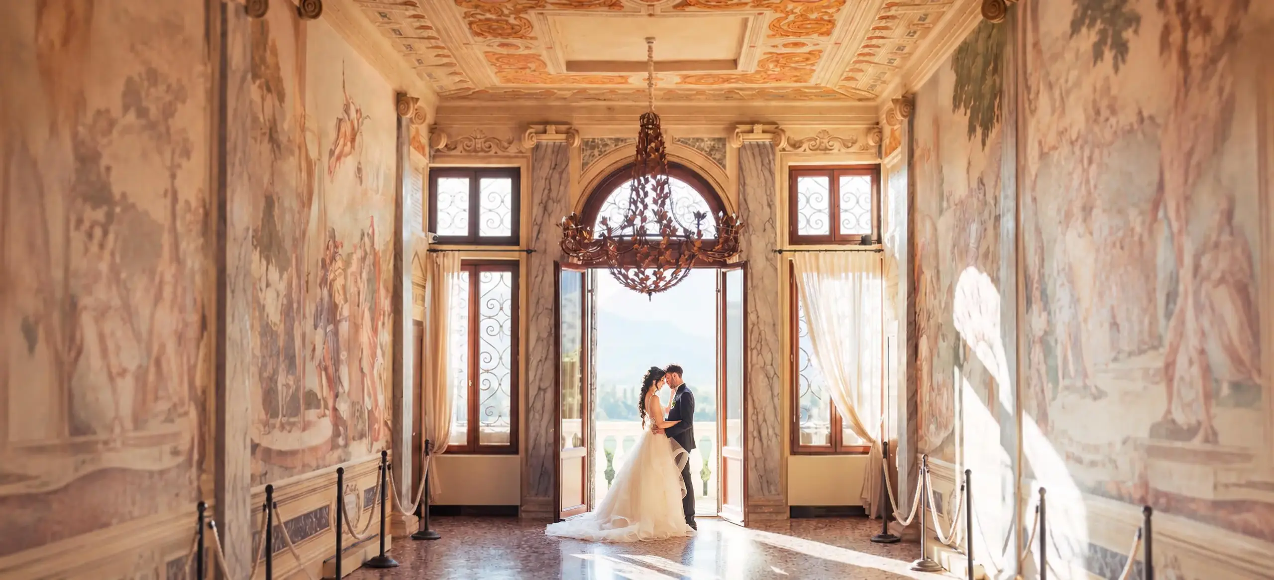 Coppia di sposi in una sala affrescata durante il matrimonio